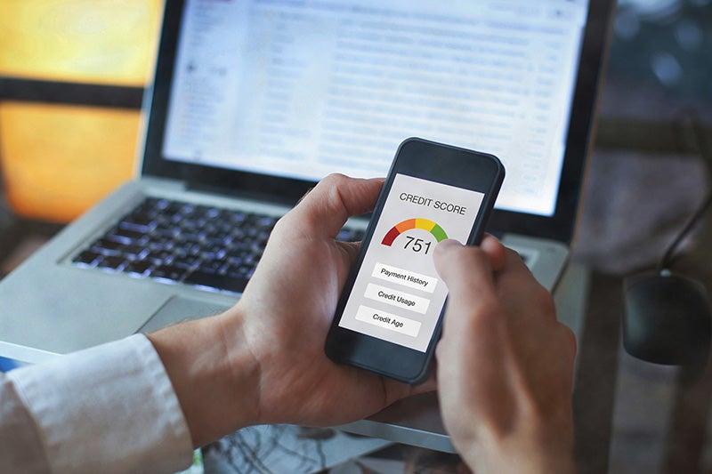 Hands holding a phone displaying a credit score